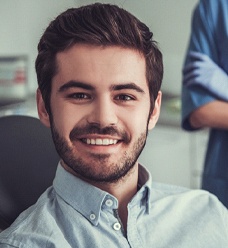 Close up of younger man smiling while sitting in the dental chair