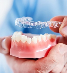 Dentist holding mouth mold and Invisalign® in Jacksonville