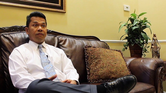 Doctor Aguila sitting on couch in dental office