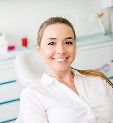 woman wearing white sitting in dental exam chair