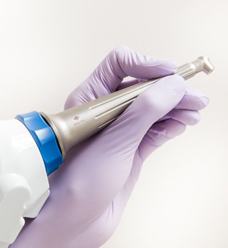 A dentist holding a dental laser