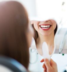 woman smiling into mirror