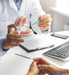 A dentist explaining tooth replacement options to a patient