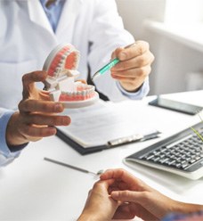 A dentist explaining tooth replacement options to a patient