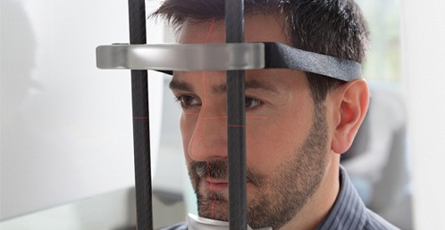 male dental patient standing in cone beam scanner in Jacksonville