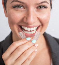closeup of woman smiling while holding clear alginer