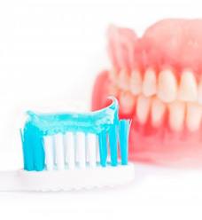 a toothbrush with toothpaste for cleaning dentures