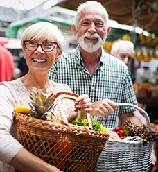 a couple walking through a farmer’s market together and smiling