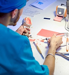 A lab worker making dentures