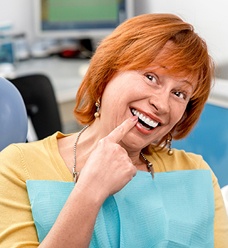 Older woman pointing to flawless smile