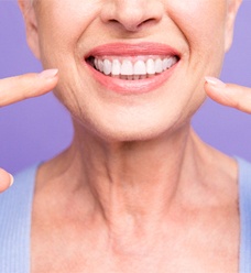 Woman pointing to her smile