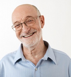 Man smiling with dental implants in Jacksonville while wearing glasses