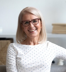 Middle aged woman smiling with dental implants in Jacksonville