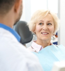 Older woman smiling during her dental implant consultation