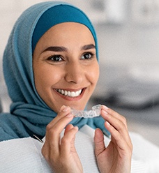 Woman holding Invisalign® in Jacksonville