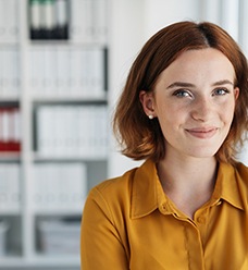Closeup of woman with red hair and orange shirt smiling