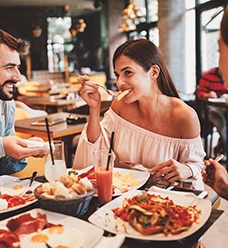 Group of friends smiling while eating lunch at restaurant