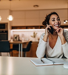 Woman smiling while talking on phone at home