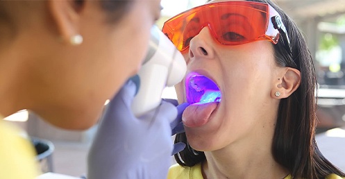 A woman sitting in the dentist chair with her dentist next to her