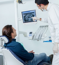 Implant dentist in Jacksonville showing patient an X ray