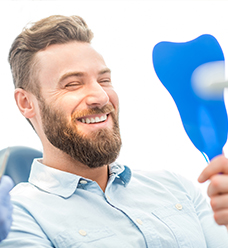 man smiling into mirror