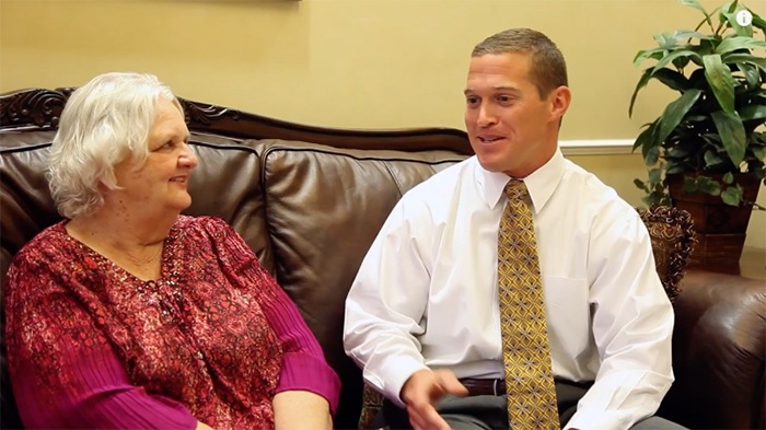 Doctor Nawrocki sitting on couch in dental office with a patient