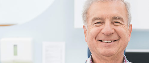 Older man in dental chair smiling