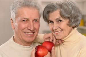 older couple eating apples