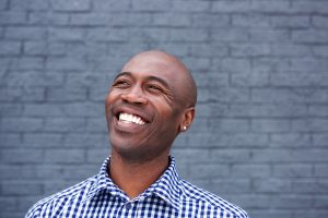 man smiling in front of gray background