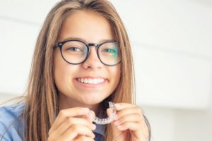 girl holding aligner