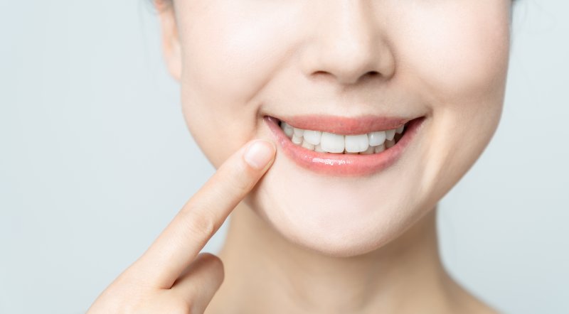 a woman pointing to her smile