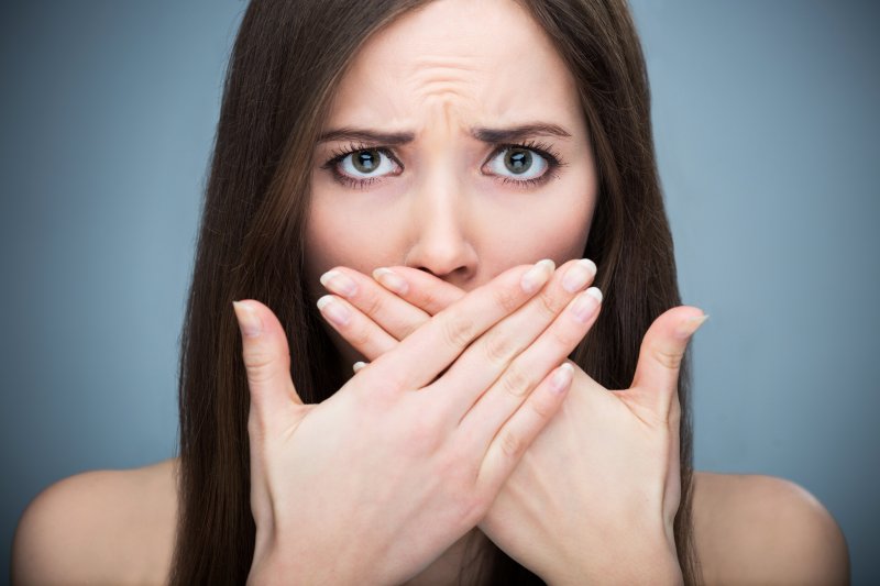 a woman with her hands over her mouth