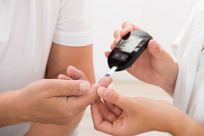 a person having their finger pricked to check their blood sugar levels
