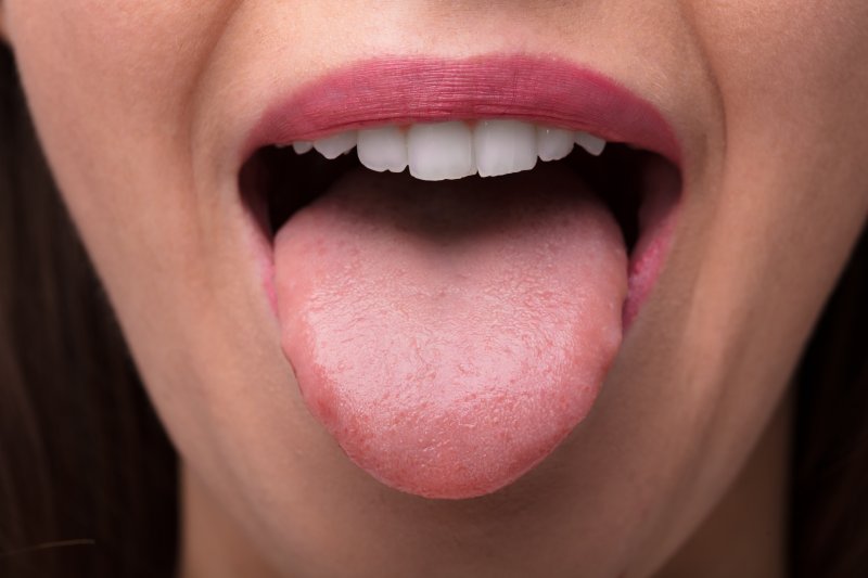 an up-close view of a person with their pink tongue sticking out of their mouth