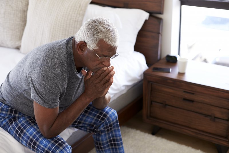 an older man sitting on the side of his bed experience the effects of Alzheimer’s disease in Jacksonville