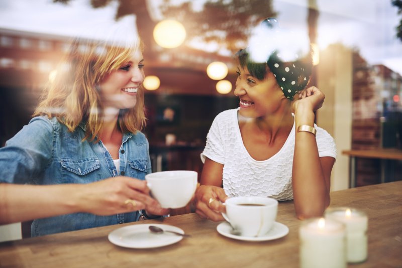 women drinking coffee with veneers in Jacksonville