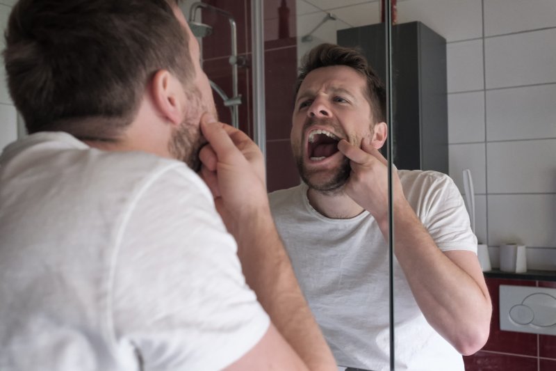 Patient checking gums in the mirror for gum disease