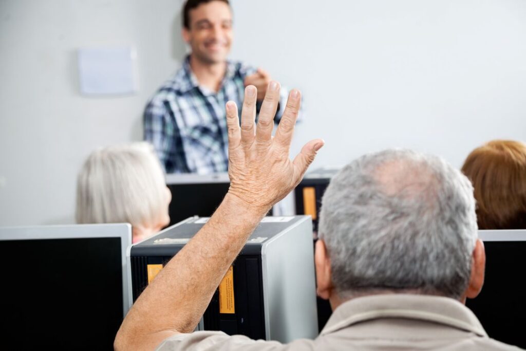 A senior raising his hand in a classroom
