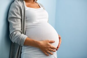 Pregnant woman holding belly. 