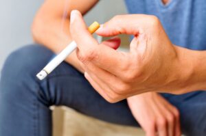 Hand holding lit cigarette